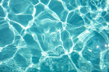 Detal of swimming pool water and sun reflecting on the surface - obrazy, fototapety, plakaty