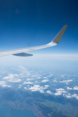 Fototapeta na wymiar Landscape with a plane wing shot out of a plane window