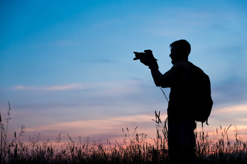 Silhouette of a young who like to travel and photographer, taking pictures of the beautiful moments during the sunset ,sunrise.