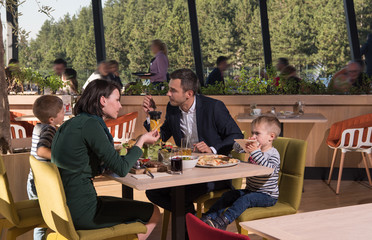 Young parents enjoying lunch time with their children
