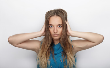 Fototapeta premium Headshot of young adorable blonde woman with cute smile on white background covers her ears with palms