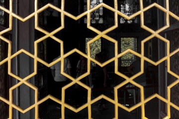 Detail of geometric arabic fence in golden colour
