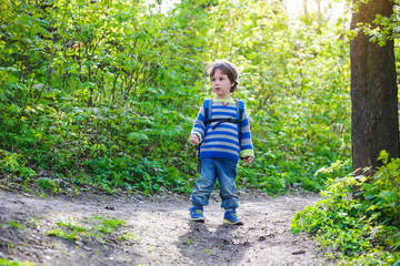 A child walks through the woods.