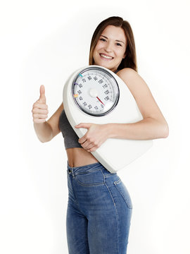 Beautiful girl with scale is proud to lose weight