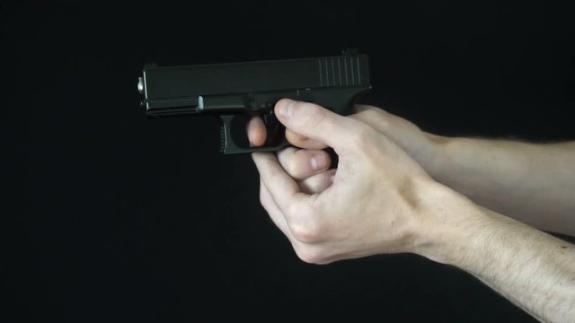 the young man reloads the clip in the gun.slow motion.