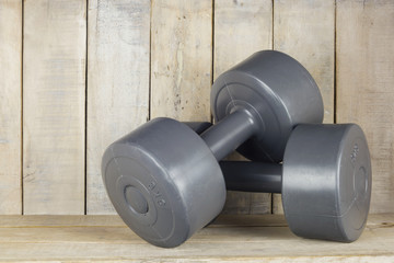 Plastic weights of 5 kgs in a wooden background