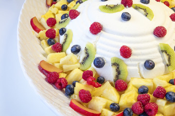 Cheese mousse with several piece of fruits such as berries, cranberries, pinneaple, kiwi