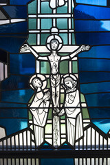 Stained glass in church showing a biblical scene of Jesus suffering in the cross