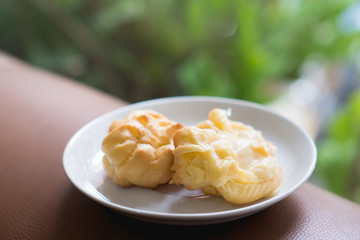 Vanilla eclair or Chu cream with egg custard on green nature background