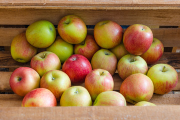 Juicy apples lying in a wooden box.
