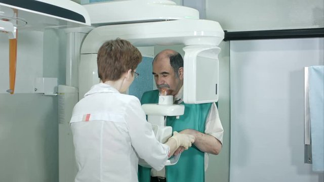 Doctor or radiologist helping senior man doing computer analyzes of teeth