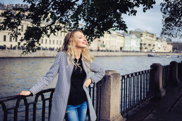 close-up portrait of a young girl hipster beautiful blonde with red lips laughing and posing against the backdrop of the city lifestyle