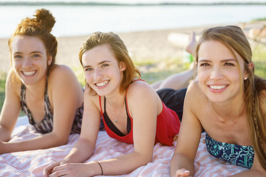 Three attractive women relaxing on a sandy beach