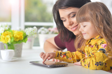 Woman and little girl using  tablet