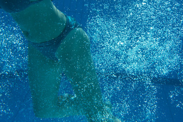 Fototapeta na wymiar Woman with swimsuit swimming on a blue water pool 