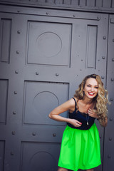 close-up portrait of a young girl hipster beautiful blonde with red lips laughing and posing against the backdrop of the city