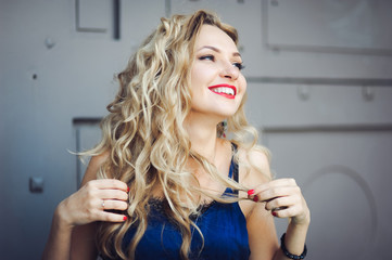 Obraz premium close-up portrait of a young girl hipster beautiful blonde with red lips laughing and posing against the backdrop of the city