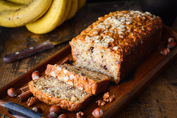 Banana bread with walnuts, cinnamon and chocolate chips on wooden tray. Closeup view, selective...