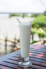 Coconut milk shake in glass on table