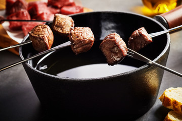 Portions of tender beef cooked in a fondue pot
