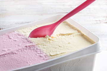 Vanilla and strawberry ice cream with a pink plastic spoon