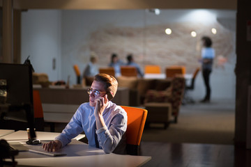 man using mobile phone in dark office