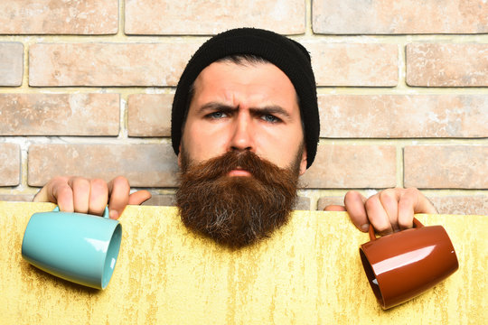 Bearded brutal caucasian hipster with paper sheet and cups
