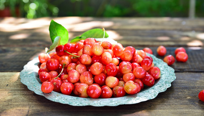 Ripe red cherry in an iron plate