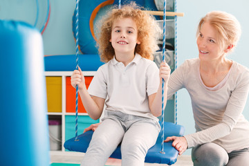 Boy sitting on a swing during therapy