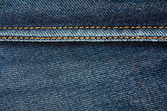 Blue denim jeans texture background with seams,close up,select focus with shallow depth of field