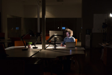 man working on computer in dark office