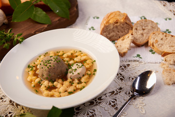 Suppe mit Knödel als Einlage und Brot serviert