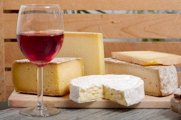 Different french cheeses with a glass of wine