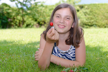 pretty teenage girl outdoors with cherry