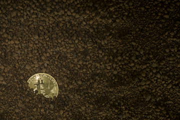 Golden bitcoin mining and trading with leather glove and spade.Low light photography.