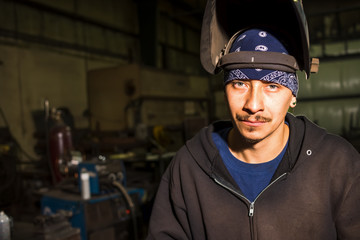 Obraz premium Environmental portrait of a welder with shield on and up
