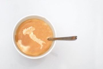 A cup of hot coffee with a map of Italia on the coffee cream