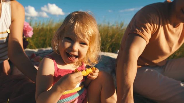 happy little girl eating a pineapple and smiling at camera