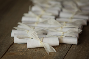 Little parchments bound with ribbon on a wooden table