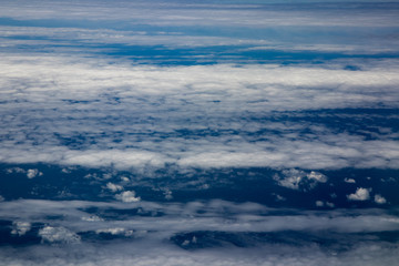 Fototapeta premium Aerial view of clouds and blue sky while flying on aircraft