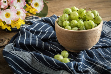 Fresh gooseberry in a wooden bowl.