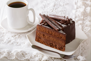 Truffle cake decorated with chocolate chips on a plate and coffee close-up. horizontal