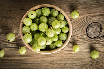 Fresh gooseberry in a wooden bowl.
