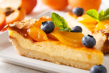 beautiful dessert: cheesecake with apricots, blueberries and almonds close-up. horizontal