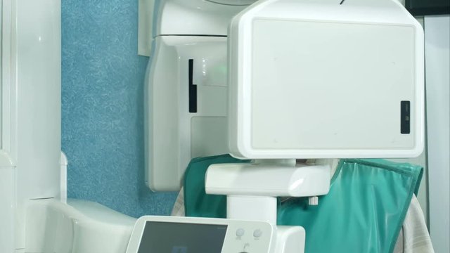 Senior patient doing examination of teeth by using panoramic and cephalometric X-Ray scanner