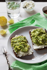 Avocado sandwich with cottage cheese on white plate