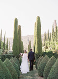Bride and groom walking in garden 