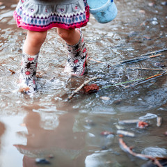 legs of little girl in rubber boots.
