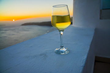 a glass of wine at sunset in Greece on the island of Santorini