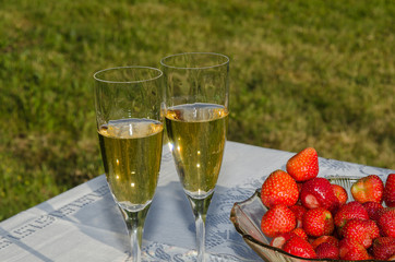 Garden table with strawberries and sparkling wine
